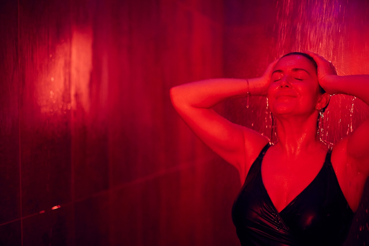Woman standing under the Rain Walk shower with water flowing over her hair.